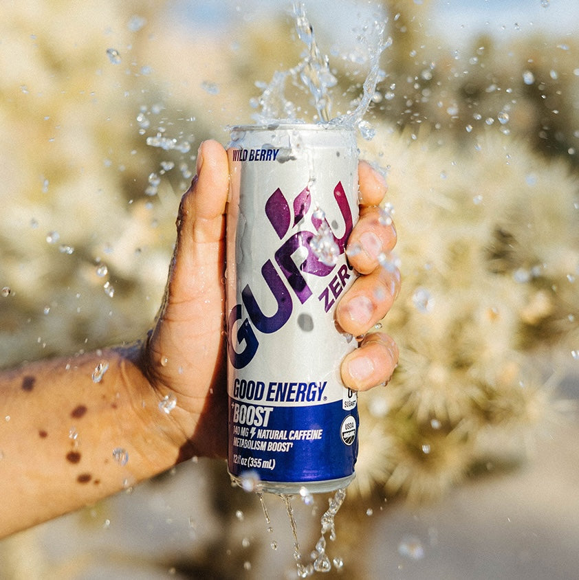 A model’s hand holds a Guru Energy Zero Wild Berry flavor can.